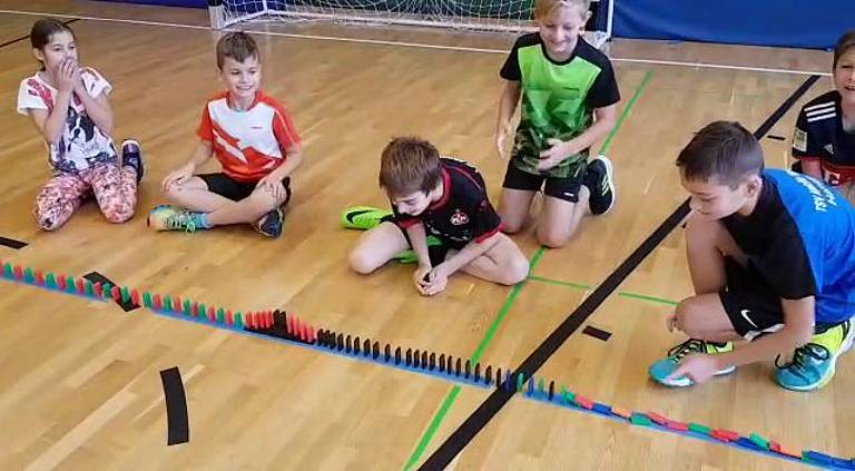 Abenteuerspiele Schüler haben in einer Linie Dominos hingestellt.