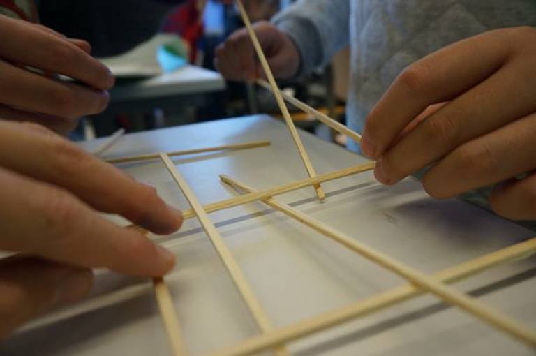 Naturphänomene Kinderhände nutzen Holzspieße für Gitternetz