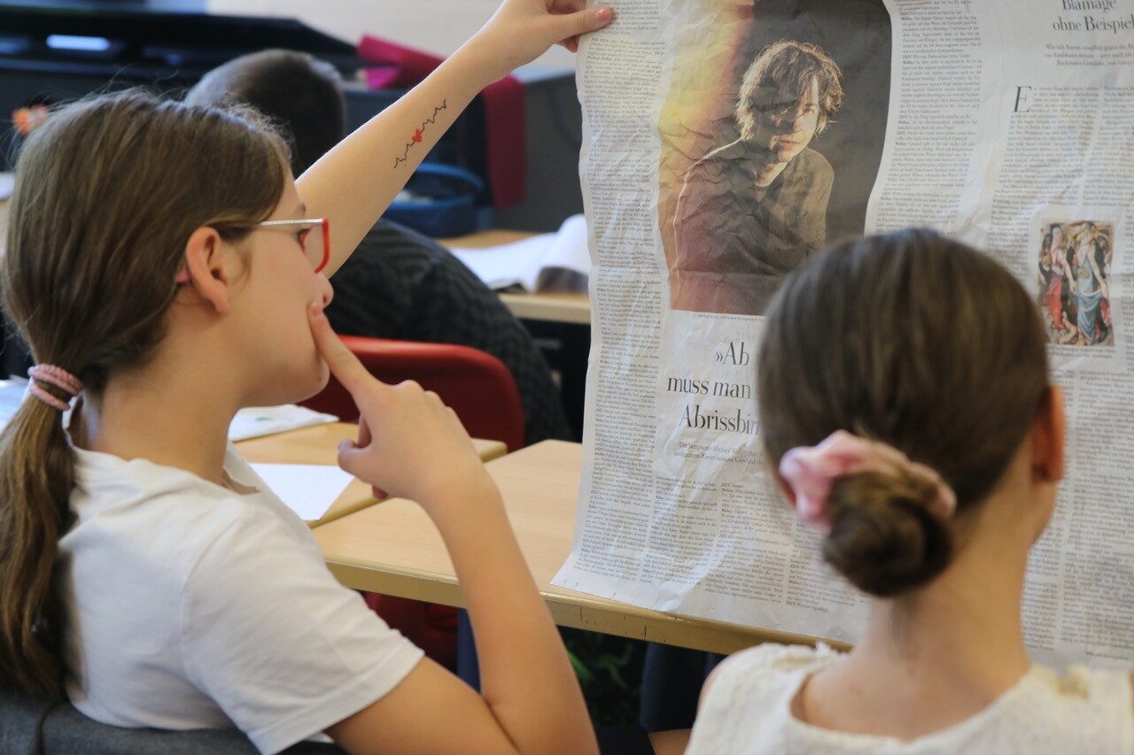 Schüler im Musikunterricht formen Zeitungspapier für ein Projekt der Neuen Musik