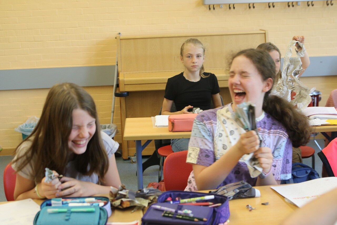 Schüler im Musikunterricht formen Zeitungspapier für ein Projekt der Neuen Musik