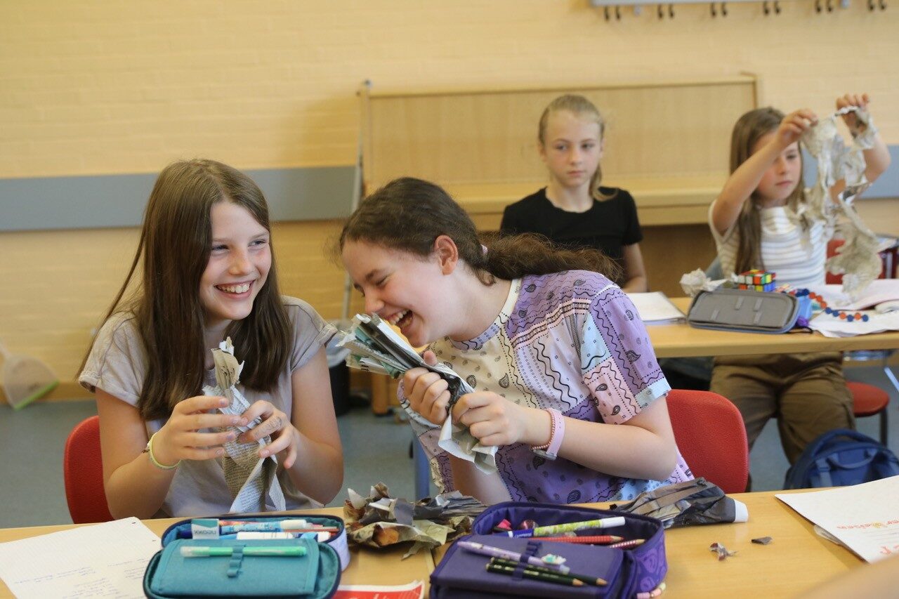 Schüler im Musikunterricht formen Zeitungspapier für ein Projekt der Neuen Musik