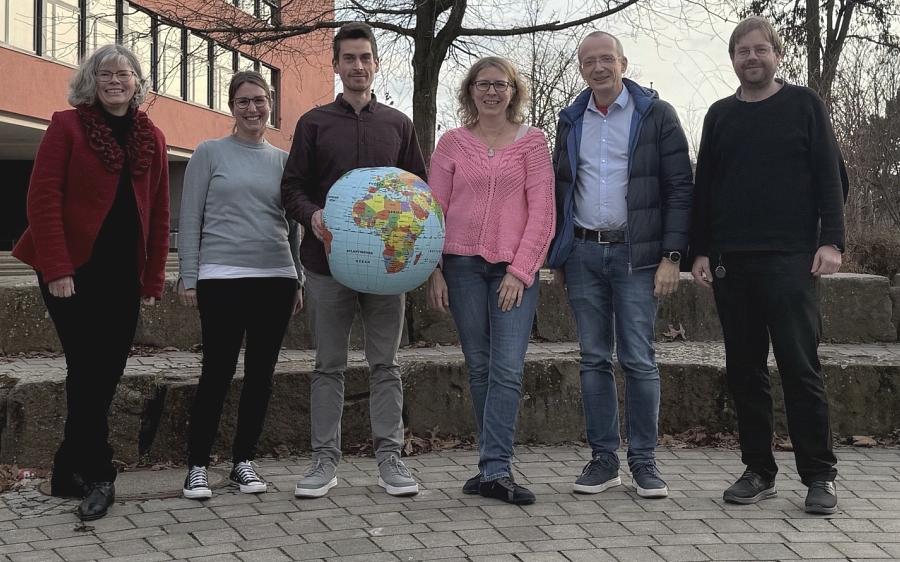 Fachschaft Geographie präsentiert sich mit einem Globus vor dem Schulgebäude der Albertus-Magnus-Schule.